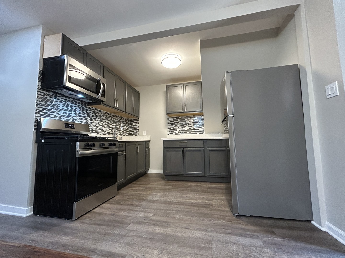 4834 North Ridgeway Avenue, Unit 3 Chicago, IL 60625 - Photo 4 of 12 a kitchen with stainless steel appliances kitchen island granite countertop a stove a refrigerator and a sink