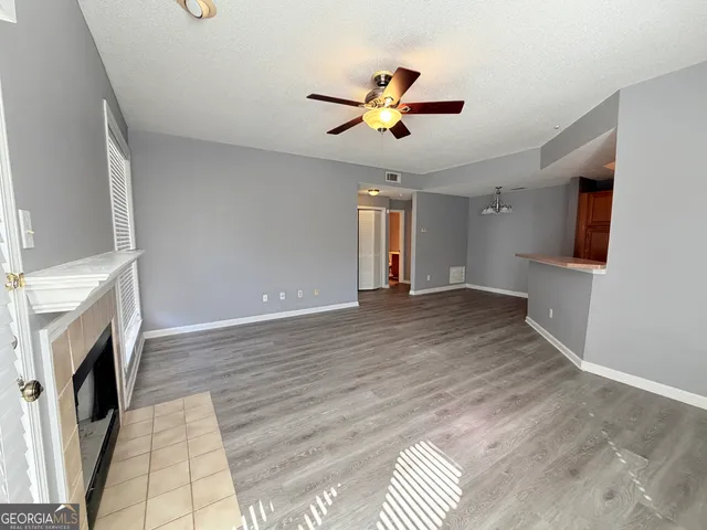 a view of an empty room with a fireplace and a window