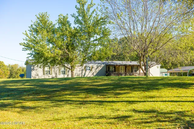 a view of a big yard with a house in the background