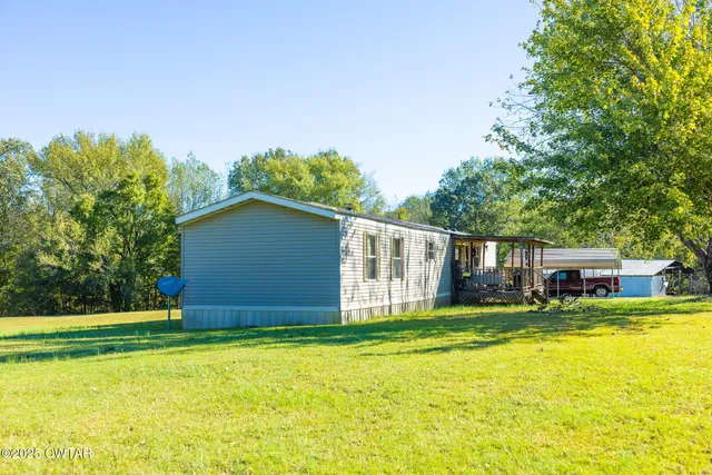 a view of yard with swimming pool and trees