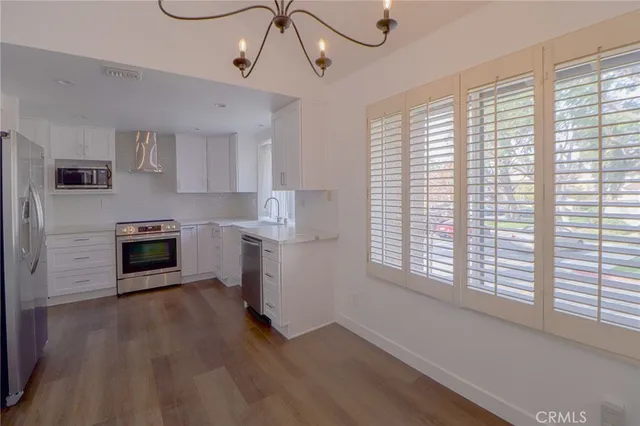 a kitchen with a refrigerator a stove and a window