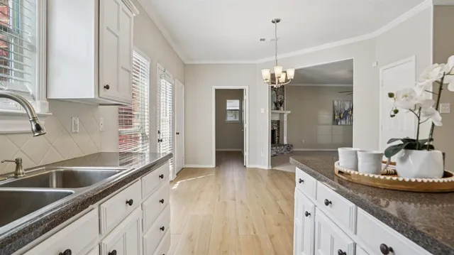 a kitchen with granite countertop a sink dishwasher and cabinets with wooden floor