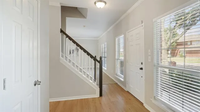 a view of a hallway with wooden floor and entryway