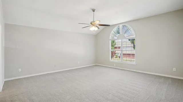 en empty room with windows and ceiling fan