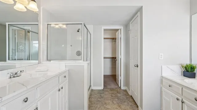 a spacious bathroom with a shower sink and mirror