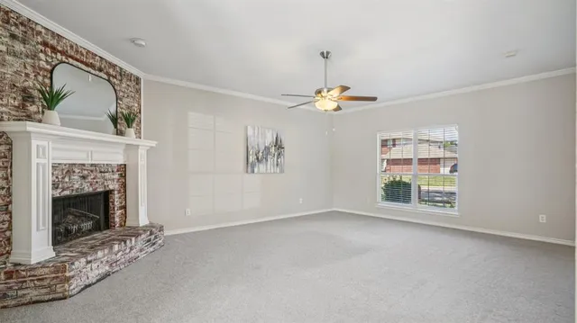 a view of an empty room with window and fireplace