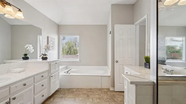 a bathroom with a tub sink and mirror