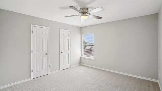 an empty room with fan and windows