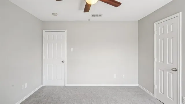 an empty room with chandelier fan