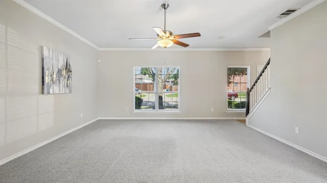 a view of big room with windows and chandelier fan