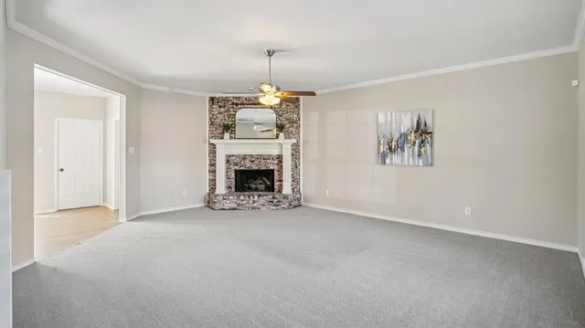 an empty room with windows fireplace and fans
