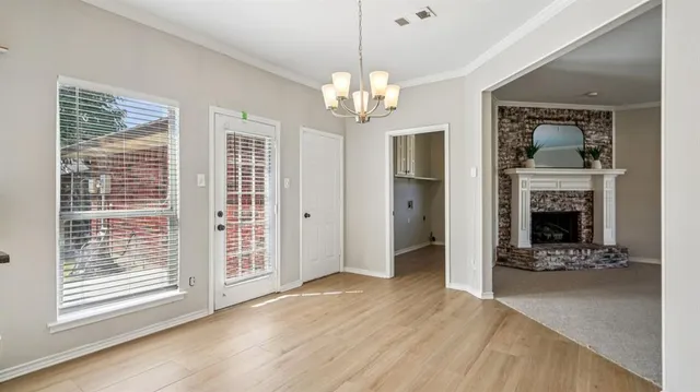 a view of a livingroom with a fireplace a chandelier and wooden floor