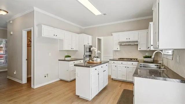 a kitchen with granite countertop a sink stove and refrigerator