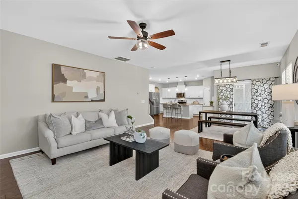 a living room with furniture and a view of kitchen