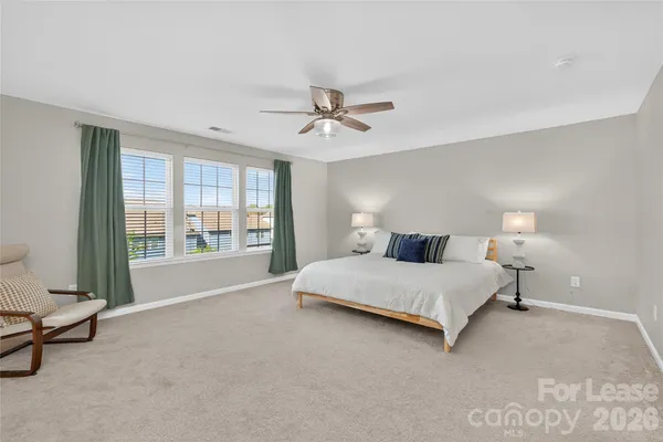 a spacious bedroom with a bed and a chandelier