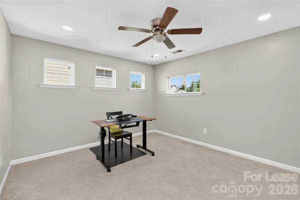 a work room with table and ceiling fan