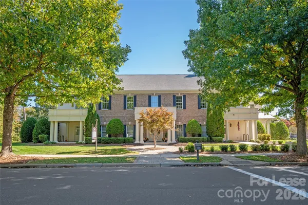 front view of a brick house with a yard