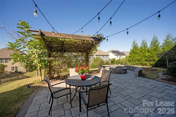 a patio with table and chairs and potted plants