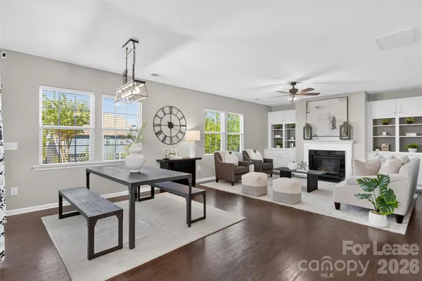 a living room with furniture a fireplace and a chandelier