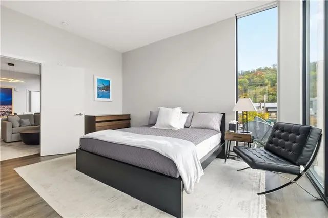 a bedroom with a bed and a large mirror next to a large window