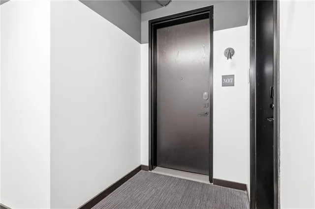 a view of hallway with furniture and a wooden floor
