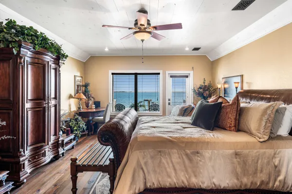 a bedroom with a bed a dresser and wooden floor