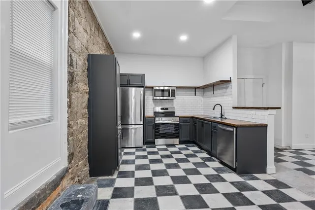 a kitchen with a checkered floor and white cabinets