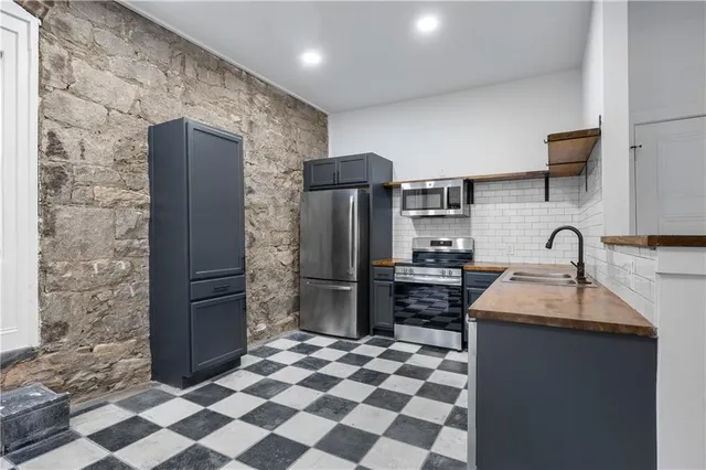 a kitchen with stainless steel appliances granite countertop a refrigerator and a sink