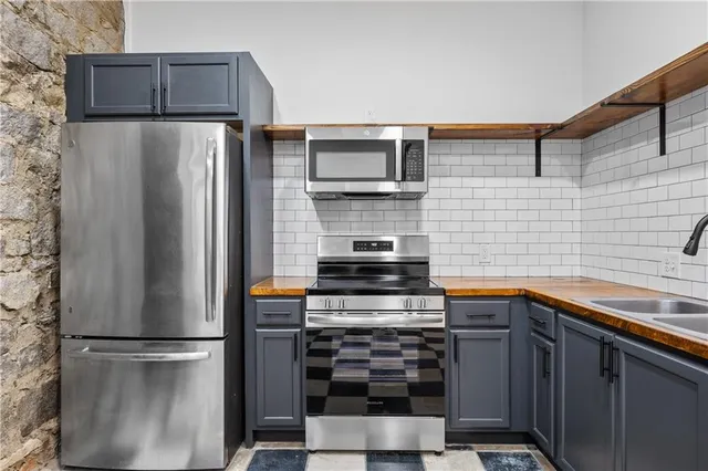 a kitchen with stainless steel appliances a refrigerator a stove and a sink