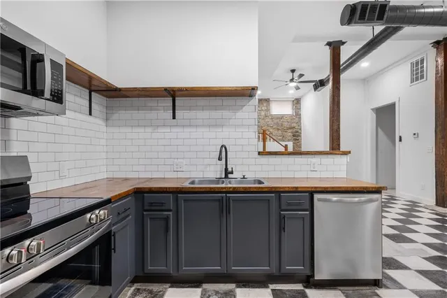 a kitchen with stainless steel appliances a sink stove and cabinets