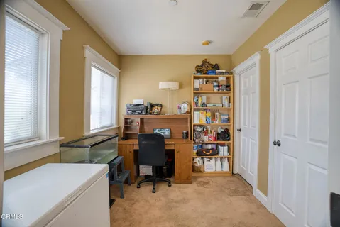 a bedroom with a bed and a flat tv screen on dresser