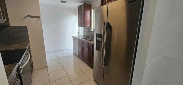 a kitchen with stainless steel appliances granite countertop a refrigerator and a stove