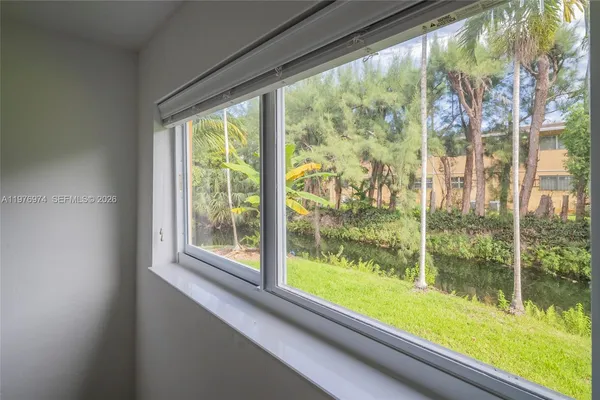 a view of a kitchen with a refrigerator wooden floor and windows