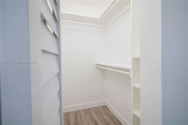 a view of walk in closet with wooden floor