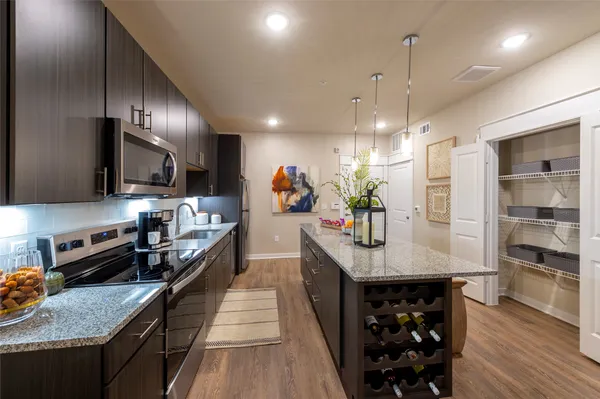 a kitchen with stainless steel appliances a sink a stove and chairs