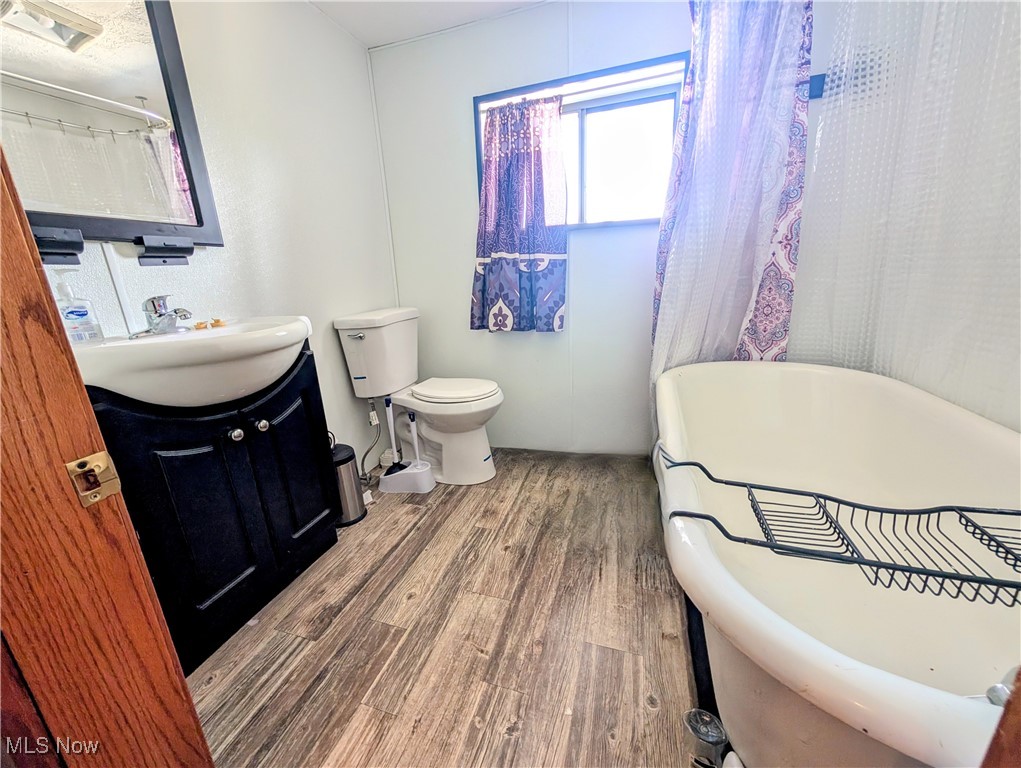77 Morgan Ridge Road Walker, WV 26180 - Photo 28 of 30 Full bathroom with vanity, wood finished floors, and a freestanding bath