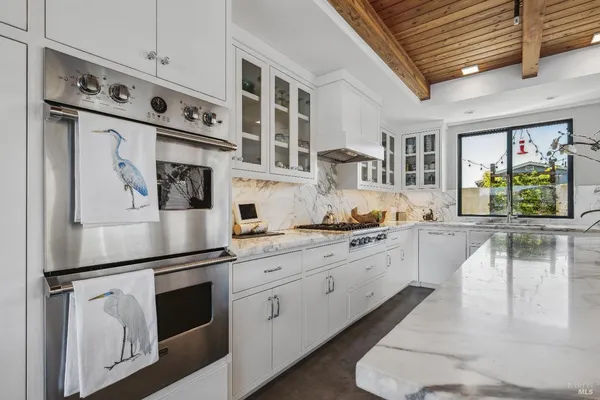 a kitchen with stainless steel appliances granite countertop a refrigerator a stove and a sink with cabinets