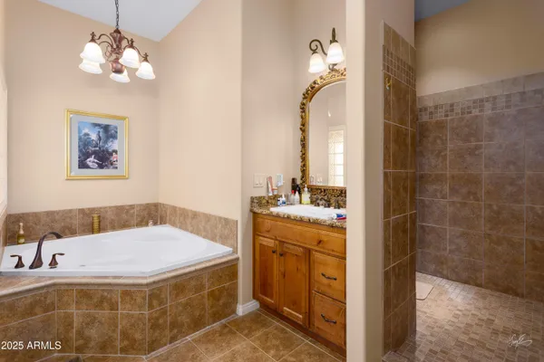 a bathroom with a granite countertop sink a mirror a vanity and a shower