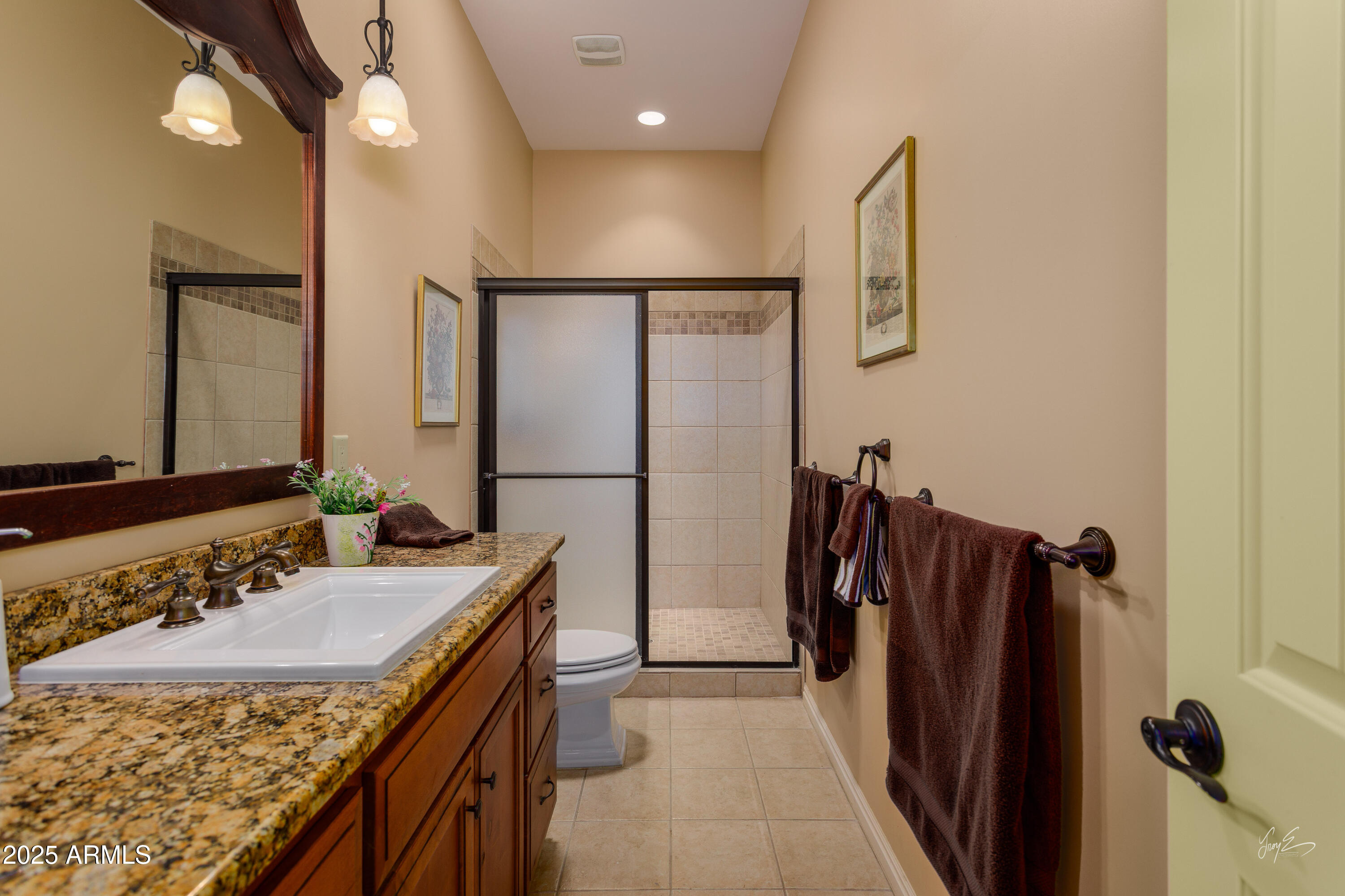 2601 South Frehner Road Littlefield, AZ 86432 - Photo 21 of 32 a bathroom with a granite countertop sink a mirror a vanity and a shower