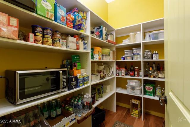 a living room with stainless steel appliances furniture rug and a table
