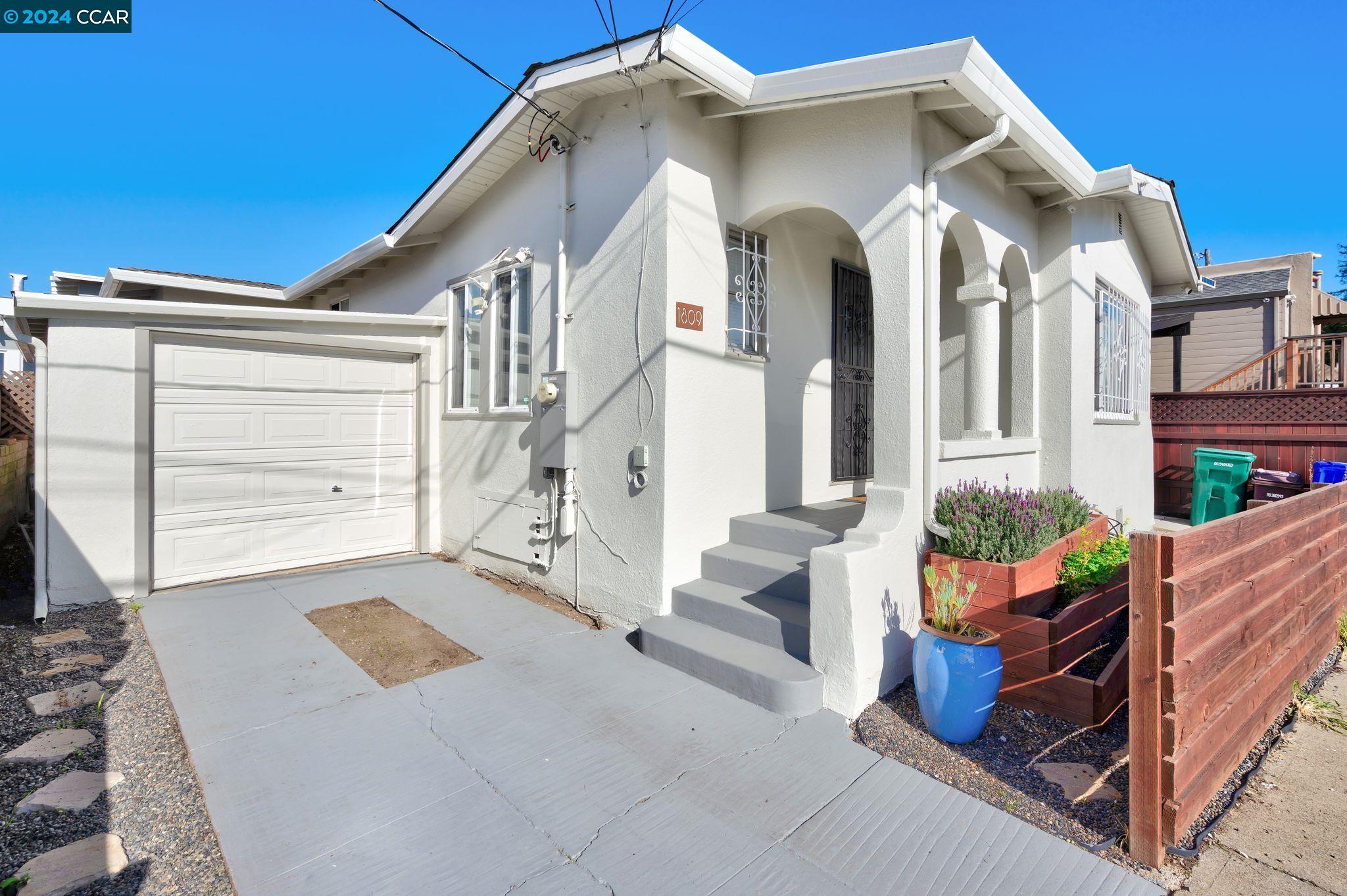 a view of a house with large windows and flower plants