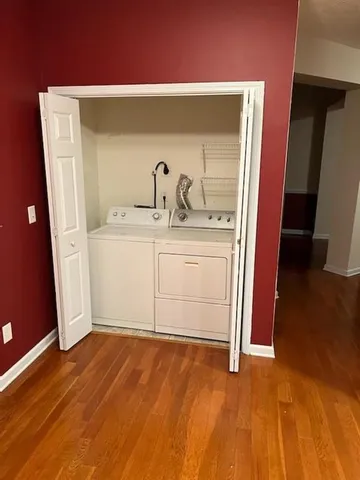 a view of an empty room with wooden floor and a cabinet