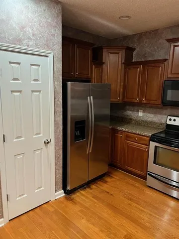 a kitchen with stainless steel appliances granite countertop a stove a sink and a refrigerator