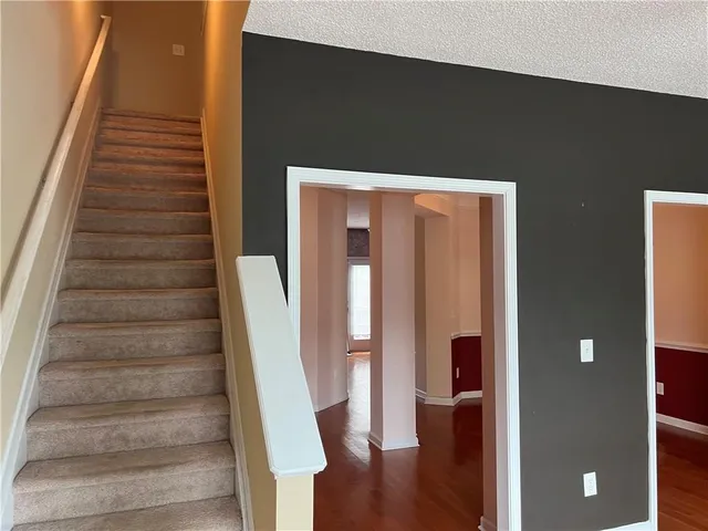 a view of staircase with wooden floor and white walls