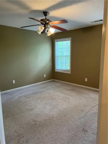 an empty room with a window and a fan