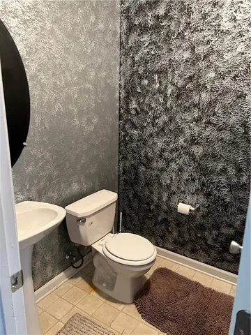 a white toilet sitting next to a shower