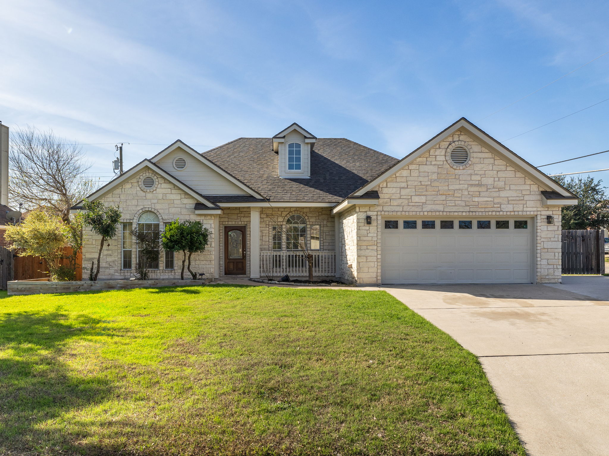 2209 Lark Lane Taylor, TX 76574 - Photo 1 of 1 View of front of house with roof with shingles, concrete driveway, an attached garage, and stone siding