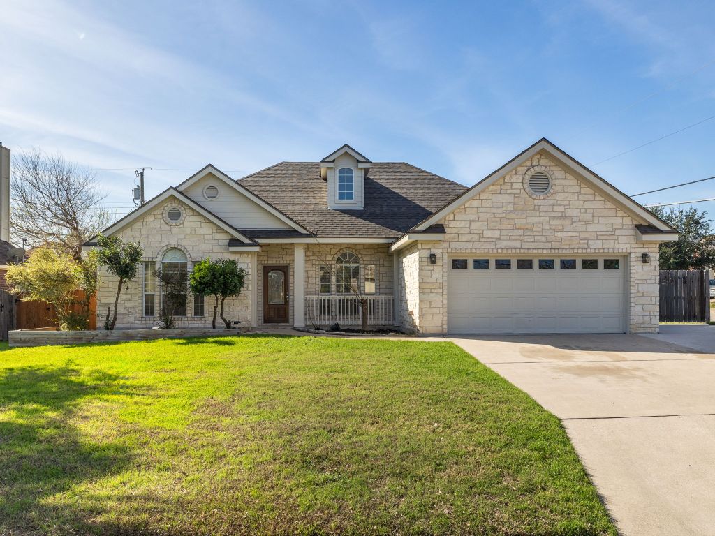 a front view of a house with a yard and garage