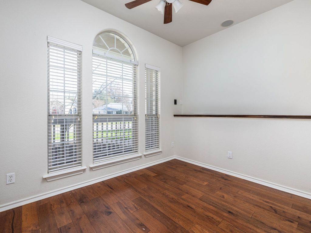 2209 Lark Lane Taylor, TX 76574 - Photo 20 of 25 an empty room with wooden floor fan and windows