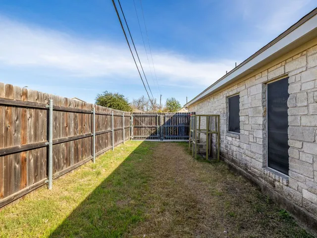 a view of a backyard with wooden fence